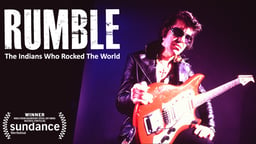 Man dressed like Elvis with a Guitar and the title Rumble